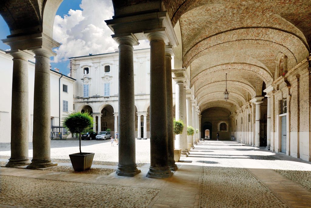 Lodi Palazzo vescovile sec. XVII il monumentale cortile con colonnato a colonne binate che formano dei dolci archi, dove filtra una luce  calda che illumina il porticato sottostante.